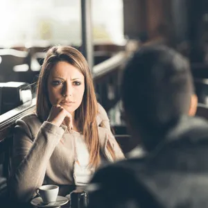 Woman looking concerned while listening, potentially noticing sudden speech problems in adults mid-discussion
