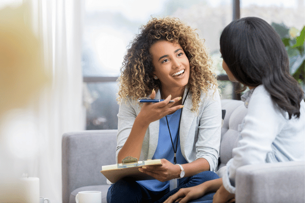 A therapist speaks with a teen girl about sudden stuttering in teenager during evaluation