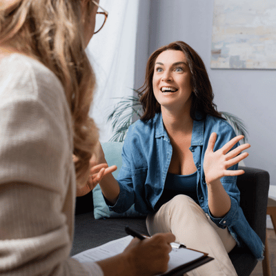 Woman enthusiastically explains her thoughts during speech therapy techniques for adults with a therapist