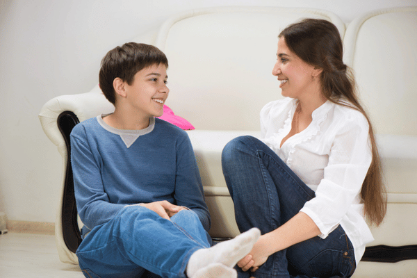Teen chats with trusted adult on couch during motivational speech for teenager about speaking up
