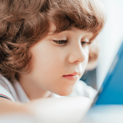 Close-up of child focusing on screen during pediatric speech therapy, practicing listening and language comprehension