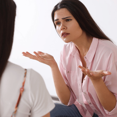 Adult speaks with expressive hands in session, highlighting benefits of speech therapy for adults support